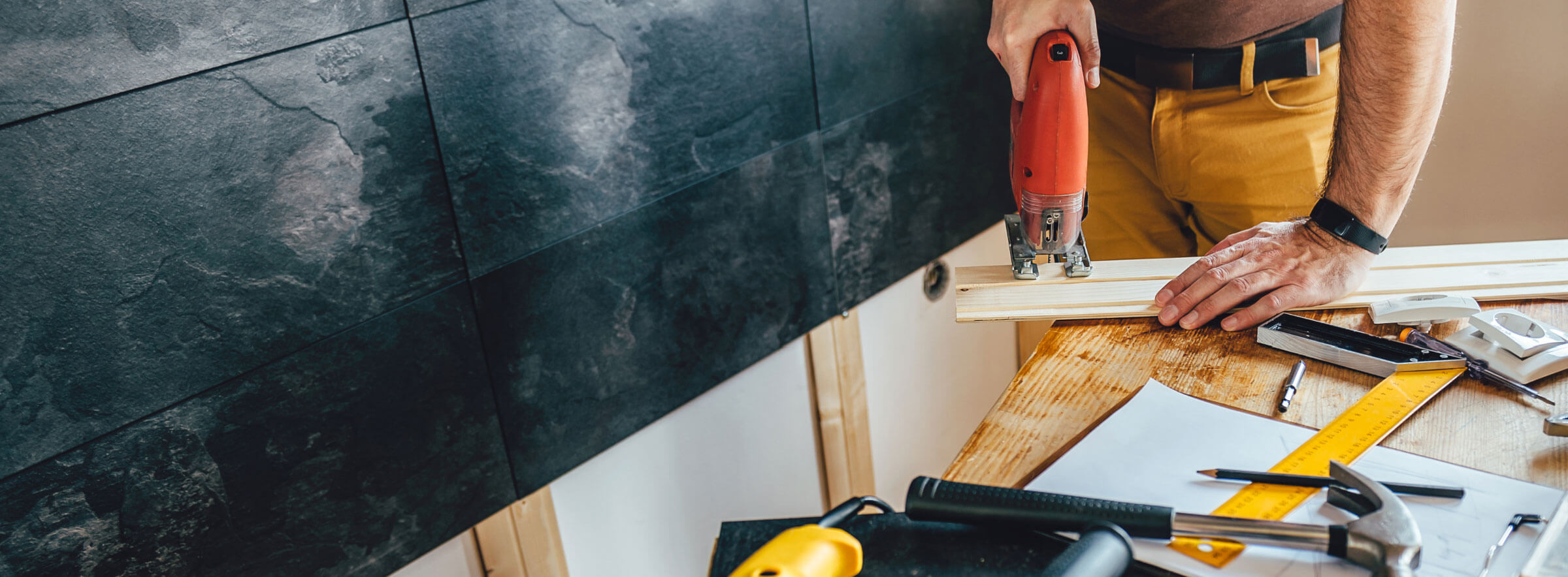 man cutting wood with electric jigsaw 1